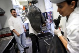 Chef Wilson Mendez (left) watches as dishwasher Max Rodas (right) and another worker take out the garbage at Luka’s Taproom, where the owner says the monthly trash bill soared from ,350 to ,250. Photo: Michael Short / Michael Short / Special To The Chronicle / ONLINE_YES