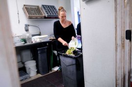 Server Carmen Anderson scrapes leftover food into a trash in the kitchen at Luka's Taproom in Oakland, CA Friday, July 24 2015.  
Because of a significant rate increase for collection in Oakland, Luka's Taproom has decided to stop composting their food waste and instead put all their trash into a landfill dumpster. Photo: Michael Short / Special To The Chronicle / ONLINE_YES